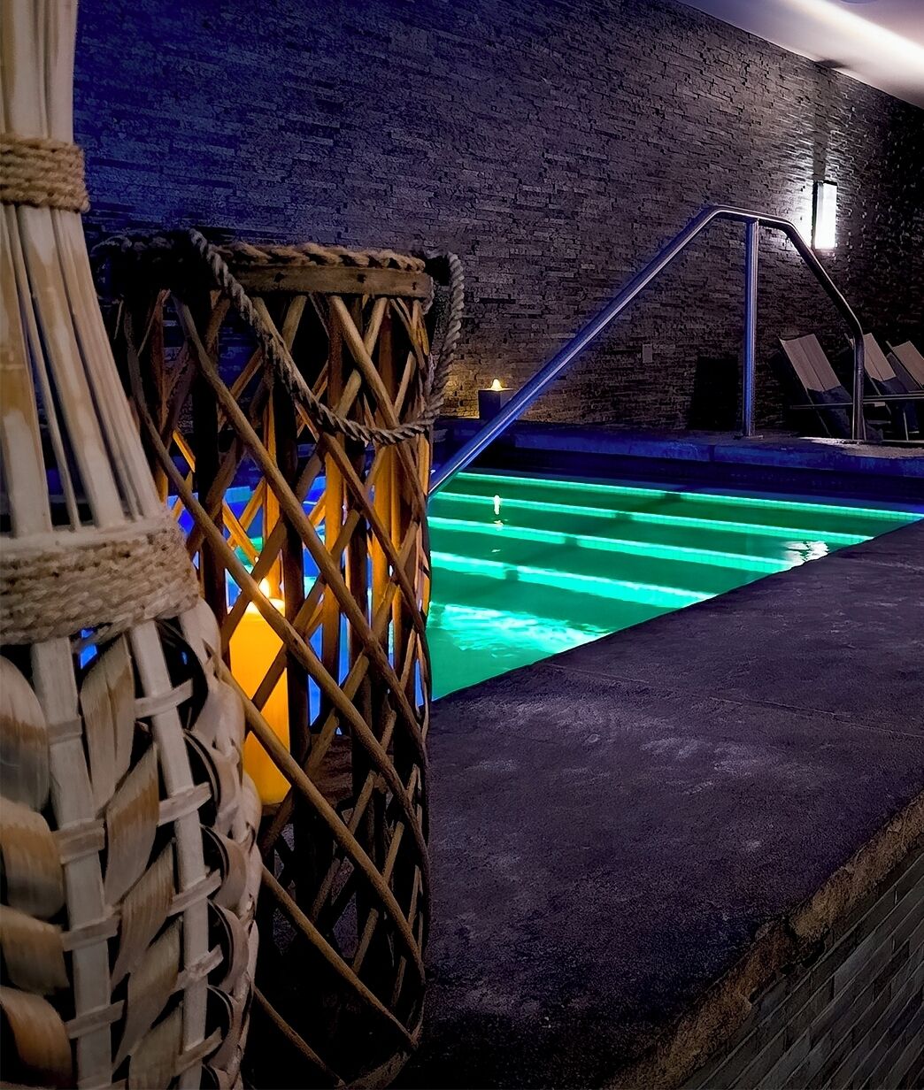 Un espace piscine agrémenté d’un mur en briques et d’une barrière faite de cordes.