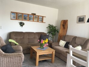 Relax in this inviting living room with a sofa, coffee table, and framed photographs.