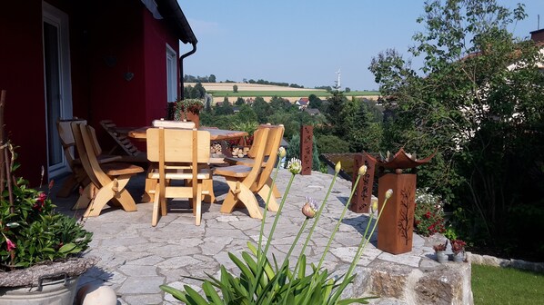 Relax in a serene outdoor space surrounded by lush greenery and a picturesque view.