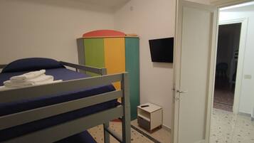 Ein Etagenbett mit blauer Matratze, ein kleiner Nachttisch und ein bunter Schrank.