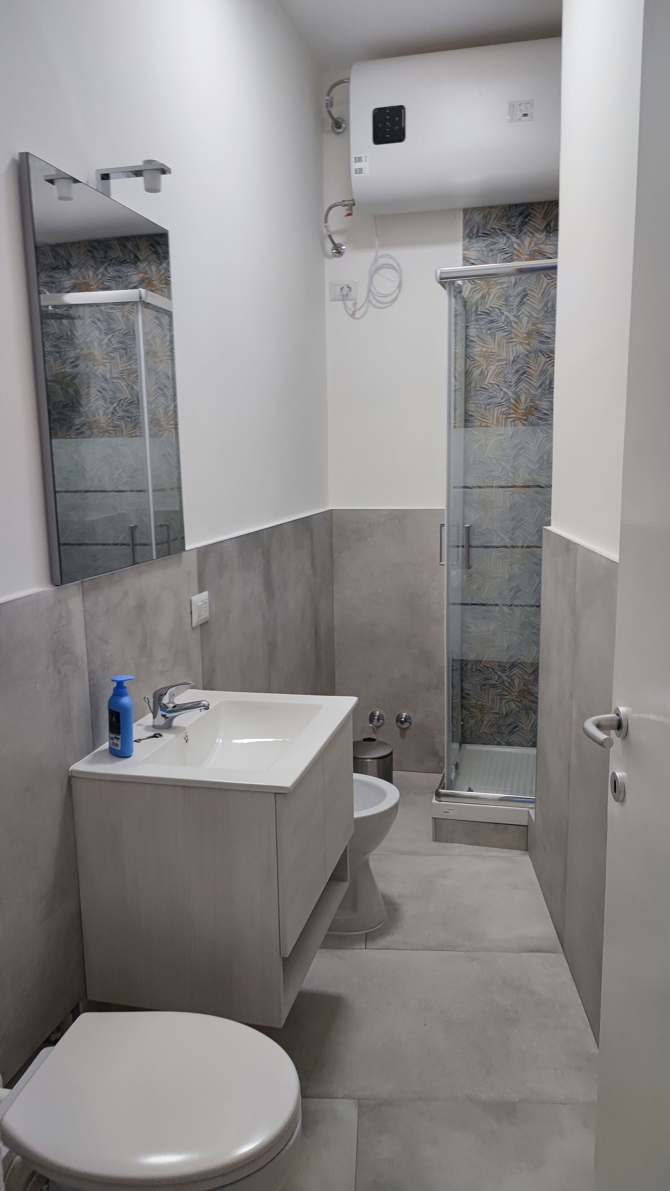Un baño moderno con inodoro, lavabo y ducha.
