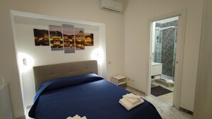 A bedroom with a bed, a nightstand, and a wall-mounted air conditioner. - Vatican Green Garden (Rome)