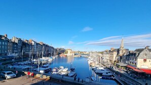 A marina with boats docked, a church spire, and buildings along the waterfront.