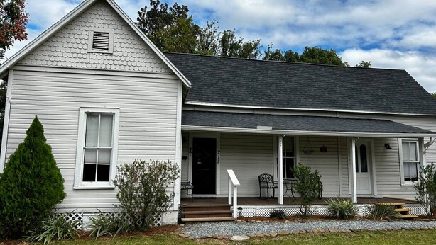 A single-story house with a front porch, a small entryway, and a visible front door.
