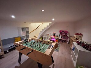 A room with a foosball table, a staircase, and a toy train display. - Maison Pour 8 Adultes et Maximum 6 Enfants Avec Piscine Chauffée, spa et Sauna (Cepoy)