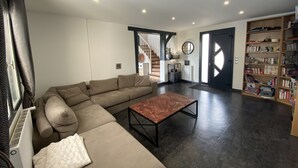 Ein modernes Wohnzimmer mit einem Ecksofa, einem Couchtisch und einem Bücherregal.