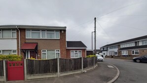 A residential street with houses, a wooden fence, and a red gate. - Luxurious home for long stay  (East Tilbury)