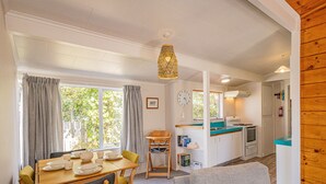 A cozy living room with a sofa and a dining area with a table set for four.