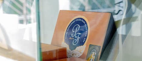 A cigar display with a prominent logo and a partial view of a window with reflections.