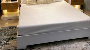 A modern bedroom with a large bed, two bedside tables with lamps, and a ceiling light fixture. - El Paso Hotel (Laguna Salada)