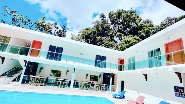 A modern hotel with a pool, multiple balconies, and outdoor seating areas. - El Paso Hotel (Laguna Salada)