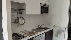 Uma cozinha compacta com forno embutido, pia e fogão.