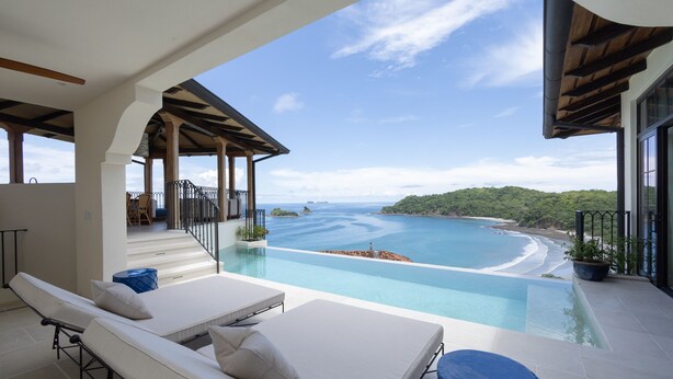 Ein Pool im Infinity-Design mit Blick auf Strand und Meer.