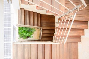 Una escalera con acabado de madera y barandilla de metal.