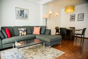 A modern living room with a sectional sofa, a dining area with a table and chairs, and a coffee table. - Condesa Residence Amsterdam 304 (Ciudad de México)