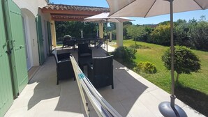 An outdoor patio area with a covered seating area, tables, and chairs. - La Bastide Saint Roch - Modern and spacious in a quiet location with a pool (La Tour-d'Aigues)