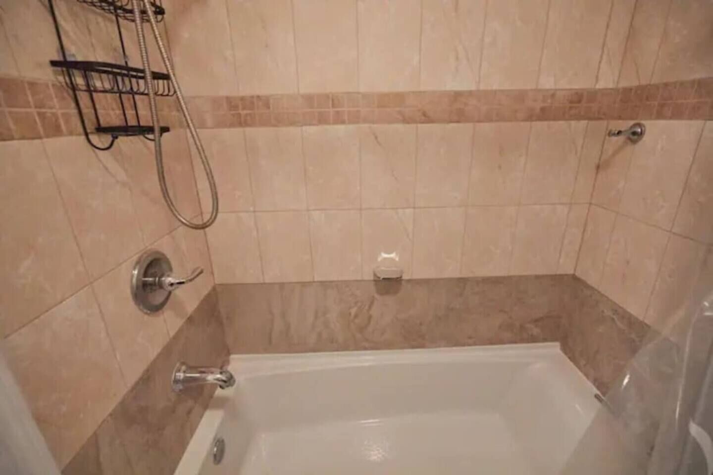 Ein Badezimmer mit einer Badewanne, einer Dusche und einem Handtuchhalter.