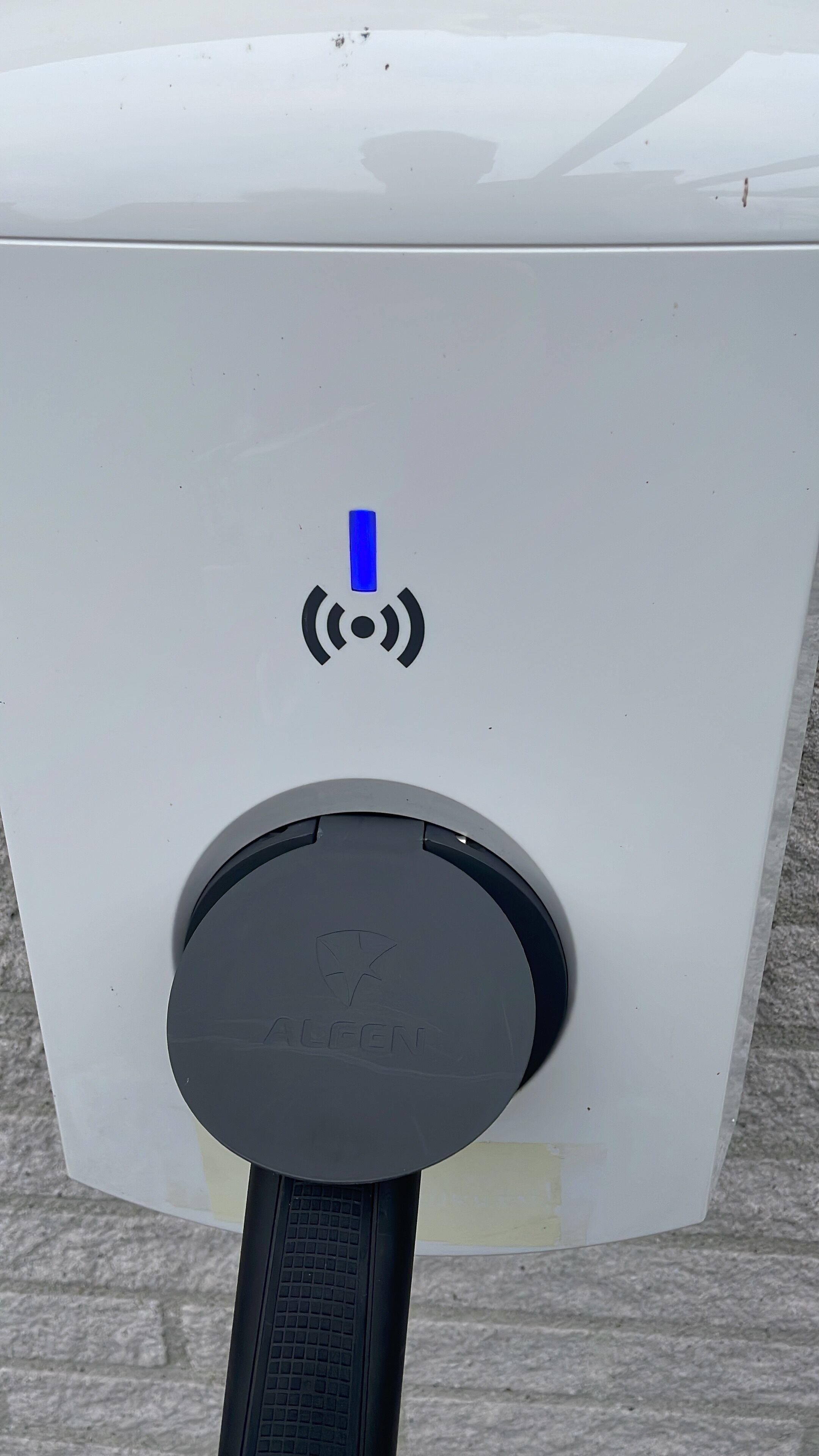 A white electric vehicle charging station with a blue power symbol and a circular charging port.