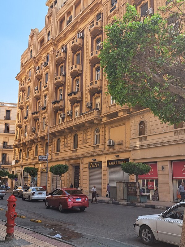 A multi-story building with balconies and a storefront.