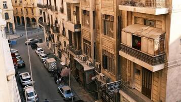 Un edificio de varios pisos con balcones y un letrero que indica Kings Palace Hostel en el cuarto piso.