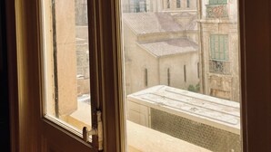 Ein Fenster mit Blick auf ein Gebäude mit einem Ziegeldach und einem Balkon.