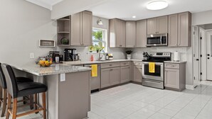 A modern kitchen with a central island, stainless steel appliances, and a breakfast bar.