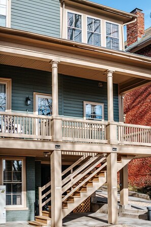 Un bâtiment à deux étages doté d’un balcon, d’un escalier et d’un mur en briques.