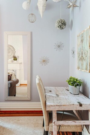A rustic dining area with a wooden table and chairs, a large mirror, and decorative wall art. - The Serendipity Suite: Desk, EV, Walk Downtown (Staunton)