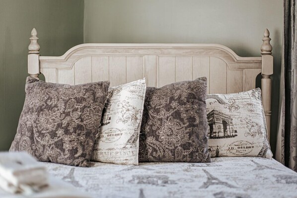 A bed with a wooden headboard and patterned pillows.