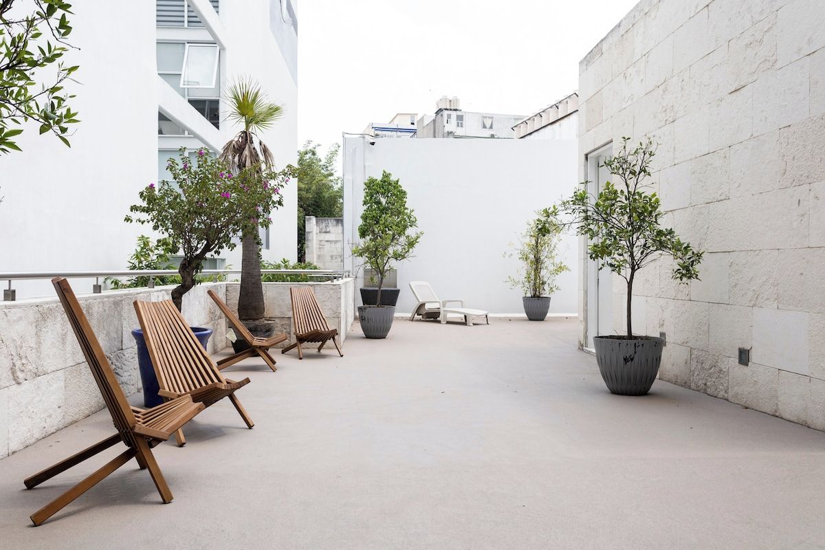 Terraza en la azotea con mobiliario y plantas en macetas.