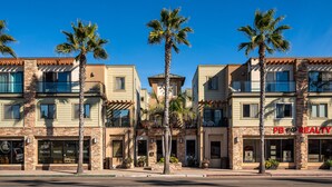 A multi-story building with a commercial ground floor featuring a salon and a realty office. - Newly Designed 2-Story Condo - 1 Block to the Beach! (San Diego)
