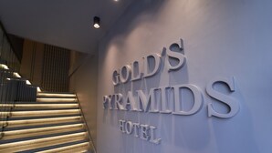 A staircase leading to a hotel entrance with the name 'Gold's Pyramid Hotel' displayed on the wall. - Gold's Pyramids Hotel (Giza)