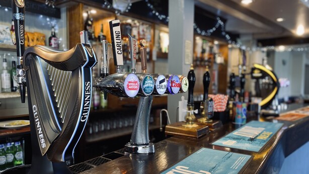 A bar with multiple taps including Guinness and Stella Artois. - Blue Bell (Kettering)