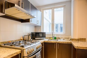 A modern kitchen with a gas stove, microwave, and stainless steel cabinets.