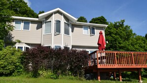 Ein zweistöckiges Haus mit rotem Deck und weißer Brüstung.