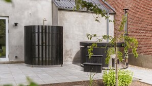 A patio area with a black metal gate, a hot tub, and a small garden with green plants. - Beautiful home in Varde with kitchen (Varde)