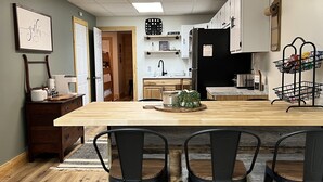 A modern kitchen with a central island, wooden flooring, and black chairs. - LakeWay II- 4 min from US-41 and Lake Sullivan (Sullivan)