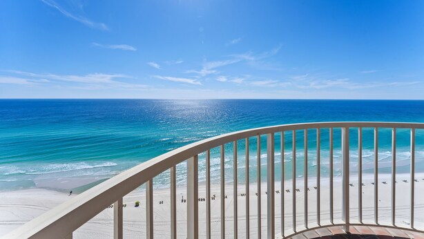 Un balcon avec vue sur une plage et l’océan.