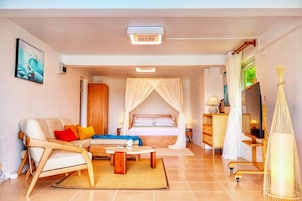 Una habitación de hotel moderna con una cama, un sofá, una mesa de centro y un televisor.