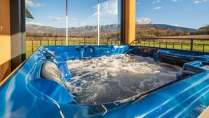 Ein Whirlpool mit Blick auf die Berge durch große Fenster.
