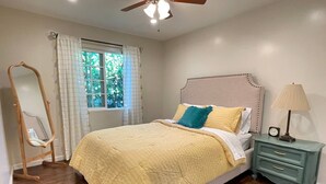 A bedroom with a bed, a nightstand, a mirror, a window with curtains, and a ceiling fan. - Bright & Airy Culver City Home w/Garden Oasis. Walkable Location + WFH Ready! (Los Angeles)