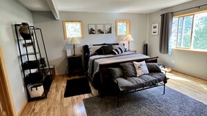 A bedroom with a bed, bedside tables, a lamp, a sofa, a rug, and a window with curtains. - Aspen Ridge-Mountain Adventure House in the Colorado Rockies-STR-0076-2026 (Fairplay)