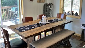 A dining area with a wooden table, chairs, a bench, a chandelier, and a view of the outdoors. - Aspen Ridge-Mountain Adventure House in the Colorado Rockies-STR-0076-2026 (Fairplay)