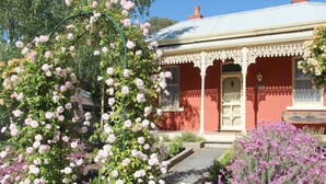 A red building with a white porch and a sign reading "WINJIN". - Winton Cottage Maldon - Authentic Heritage Home. (Maldon)
