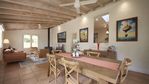 A spacious dining area with a wooden table and chairs, a fireplace, and artwork on the walls. - Winton Cottage Maldon - Authentic Heritage Home. (Maldon)