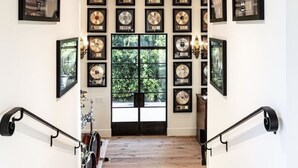 A staircase with wooden steps and a wooden ceiling, leading to a door with a view of greenery outside. - New Malibu Estate ~ Recording Studio, Tennis, Pool (Malibu)