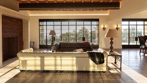 A spacious living room with a large window, a fireplace, and a leather sofa. - New Malibu Estate ~ Recording Studio, Tennis, Pool (Malibu)