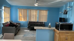 A compact living space with a kitchenette, a sofa, a dining table, and a TV. - Attention Snowbirds! (Fort Myers)