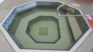 A hexagonal pool with a central drain, surrounded by a tiled border. - Attention Snowbirds! (Fort Myers)