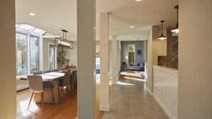 Une cuisine moderne dotée d’un îlot central, de grandes fenêtres et offrant une vue sur l’extérieur.